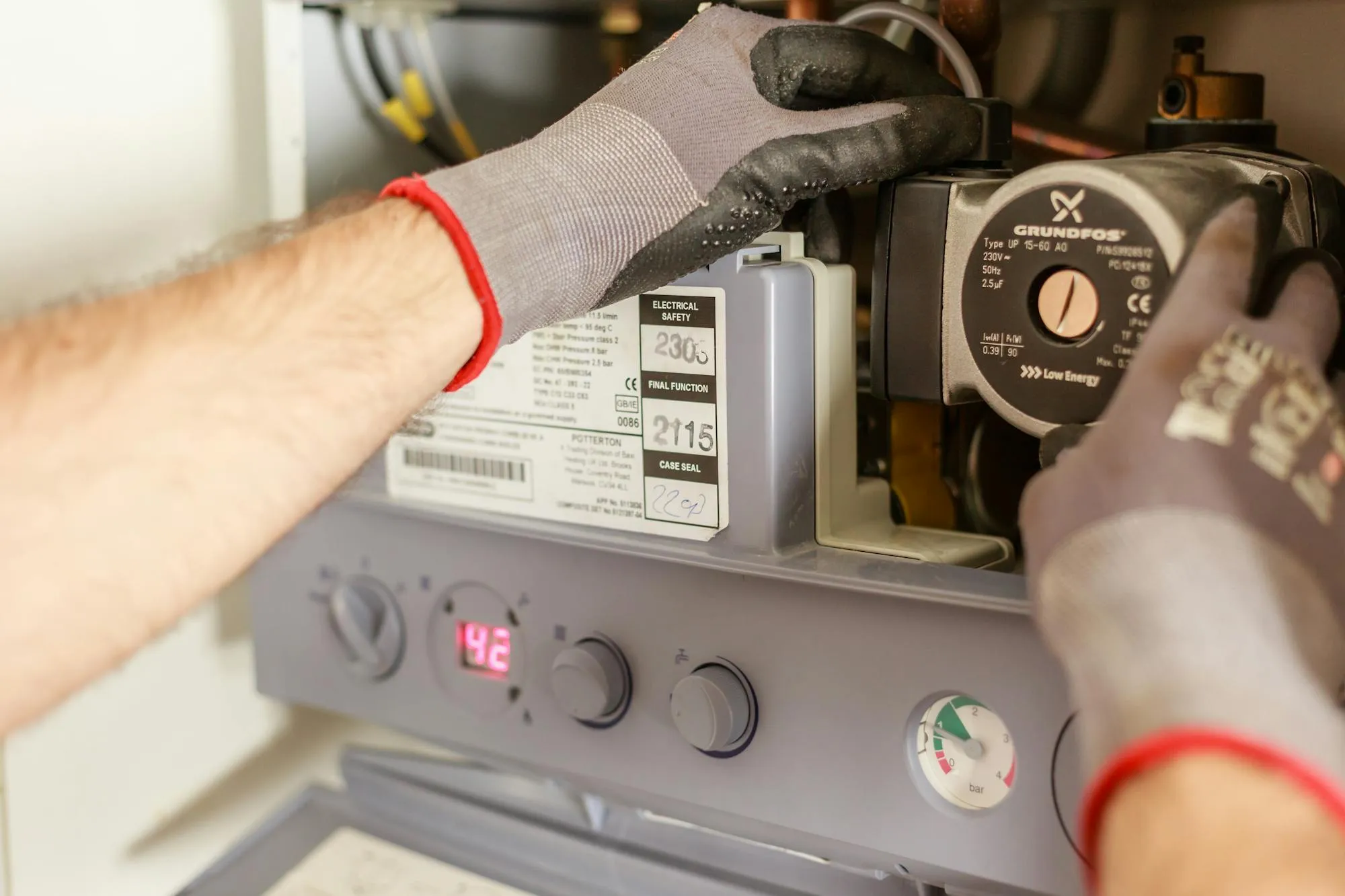 Engineer's hands adjusting a boiler control panel